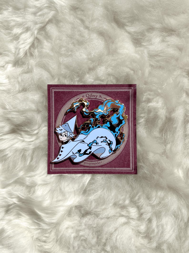 May include: Enamel pin featuring a character with white hair and a light blue cloak, surrounded by blue and brown stylized flames. The pin is set on a burgundy background with the name "Qifrey" and the text "prescopipeko".