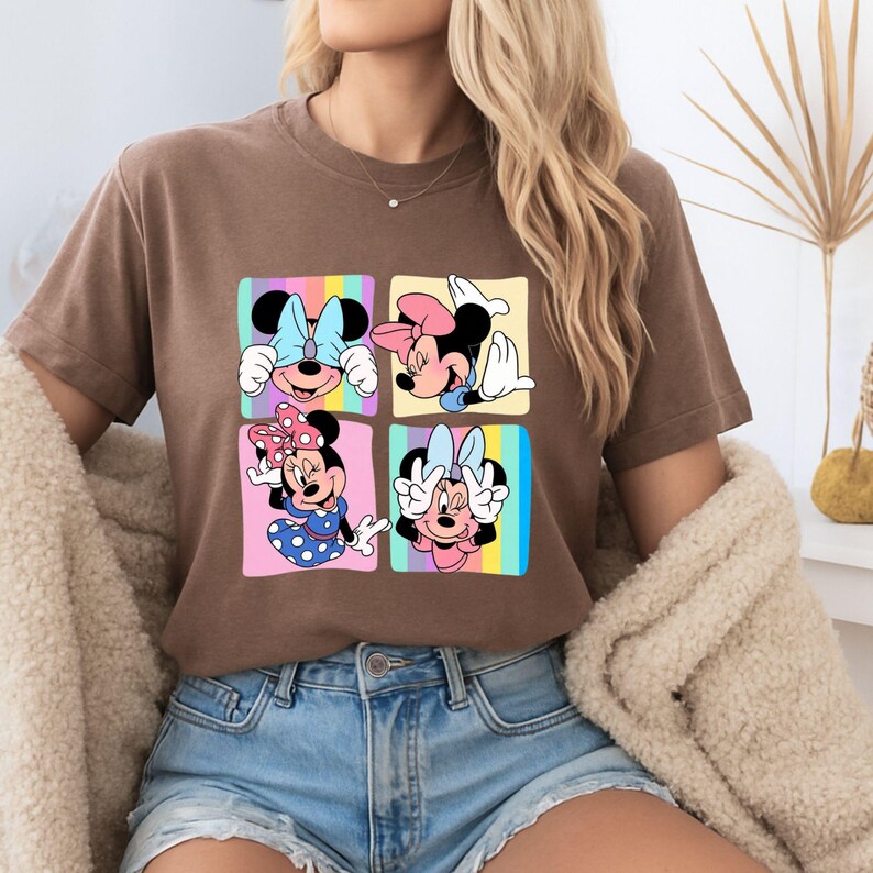 Może przedstawiać: Brązowa koszulka z kolorową grafiką Myszki Minnie w czterech r&oacute;żnych pozach. Każda poza jest umieszczona w kwadracie z pastelowym tłem. Koszulka wykonana jest z miękkiego materiału i nadaje się do noszenia na co dzień.