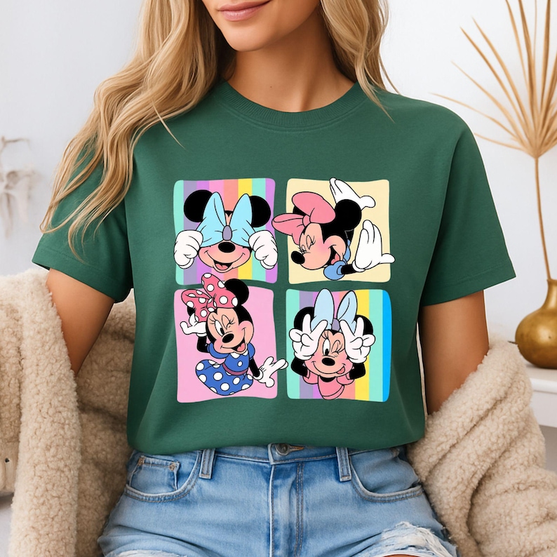 Może przedstawiać: Zielona koszulka z kolorową grafiką Myszki Minnie w czterech r&oacute;żnych pozach. Każda poza jest umieszczona w kwadracie z pastelowym tęczowym tłem. Myszka Minnie nosi kokardy i sukienki w r&oacute;żnych kolorach.