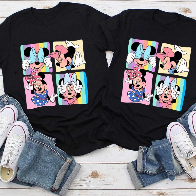 Może przedstawiać: Dwie czarne koszulki z kolorową grafiką Myszki Minnie. Każda koszulka ma cztery kwadraty z r&oacute;żnymi pozami Myszki Minnie na tęczowym tle. Koszulki są połączone z niebieskimi dżinsami i białymi trampkami.