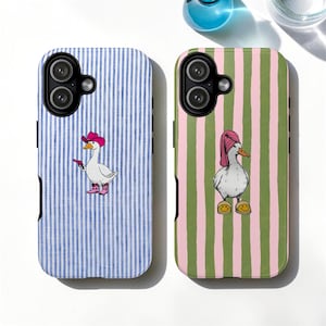 Op de afbeelding: Twee telefoonhoesjes met grillige ganzenillustraties. Eén hoesje heeft een blauw-witte gestreepte achtergrond met een gans met een cowboyhoed en laarzen, die een pistool vasthoudt. De andere hoes heeft een groen-roze gestreepte achtergrond met een gans met een handdoek en slippers.