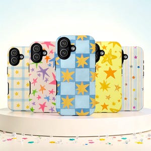 Pode incluir: Cinco capas de telemóvel retangulares dispostas em fila, cada uma com padrões distintos, incluindo xadrez azul e branco, estrelas multicoloridas desenhadas à mão, um tabuleiro de xadrez azul e azul claro com estrelas amarelas, amarelo com estrelas laranja e riscas verticais.