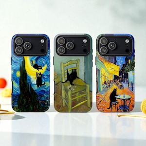 Op de afbeelding: Drie telefoonhoesjes met artistieke ontwerpen. Eén hoesje toont een sterrennachtscène met zwarte katten, een ander toont een kat op een stoel en de derde toont een caféscène met een kat. Elke hoes heeft een zwarte cameramodule.
