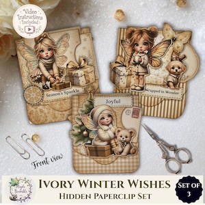Può includere: Un set di tre fermagli decorativi con illustrazioni di fate, regali, un cucciolo e un orsacchiotto in tonalità beige e crema. Le carte riportano le scritte Season's Sparkle, Wrapped in Wonder e Joyful, insieme a due fermagli in metallo e forbici in stile vintage.