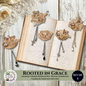 May include: A set of five decorative journal charms featuring vintage-style paper cutouts with illustrations of butterflies, birds, nests, and script text. Each charm includes a metal chain dangle with various small charms like keys and crosses.