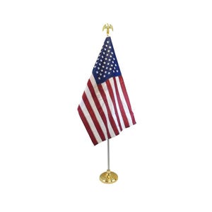 May include: A small American flag with red and white stripes and a blue field of stars. The flag is mounted on a gold-colored pole and base, topped with a decorative eagle. The flag is displayed against a white background.