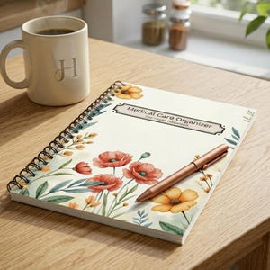 Medical care organizer spiral notebook with floral cover on a kitchen table beside a mug in soft natural light