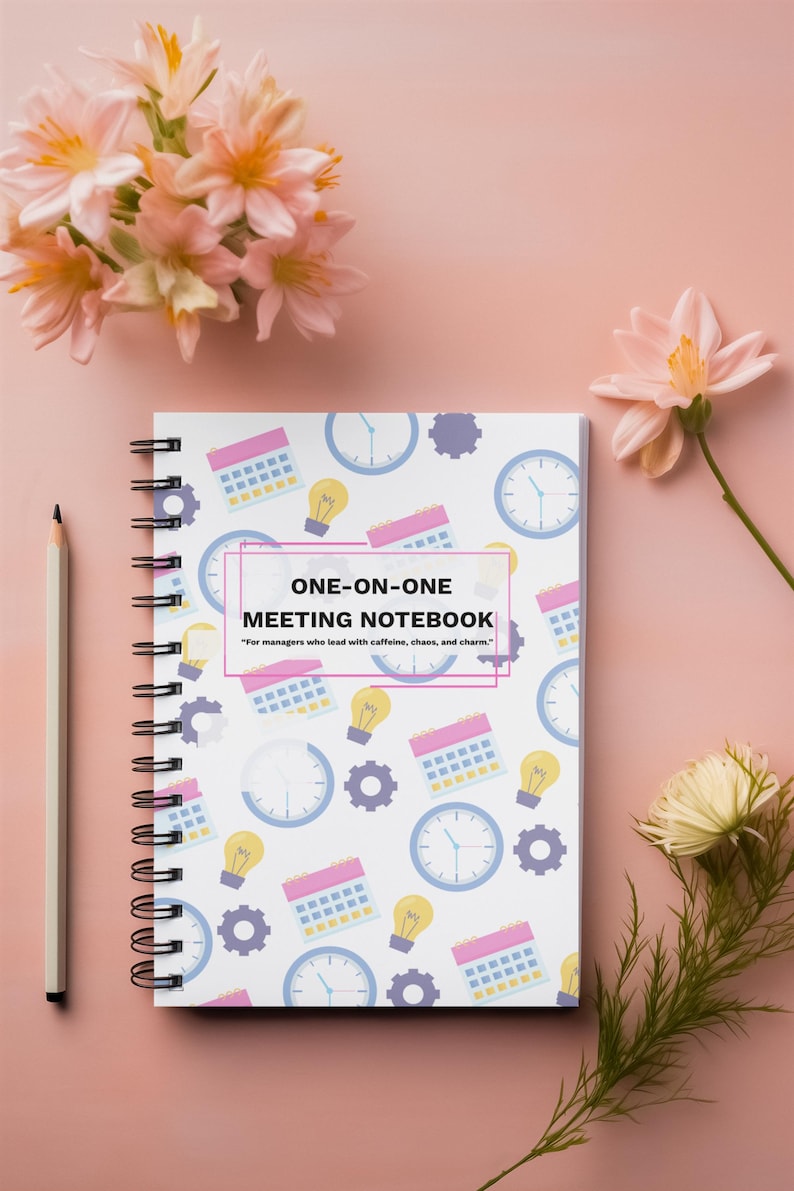 Colorful One-on-One Meeting Notebook spiral planner on pink desktop with flowers and office accessories
