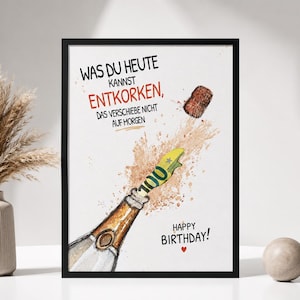 Könnte beinhalten: Ein gerahmter Druck mit einer Champagnerflasche, aus deren Flaschenhals ein 100-Euro-Schein ragt, während der Korken nach oben fliegt. Der Text lautet: WAS DU HEUTE KANNST ENTKORKEN, DAS VERSCHIEBE NICHT AUF MORGEN und HAPPY BIRTHDAY! mit einem roten Herz.