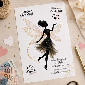 May include: A rectangular greeting card featuring a black silhouette of a fairy with iridescent wings and a glittery dress. The text reads: Happy Birthday! Sei immer DU SELBST, F&uuml;r Dich!, Bleib so Einzigartig und Mutig voller Tr&auml;ume, wie du bist. Glaub immer daran, wie Stark du wirklich bist.