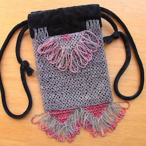 May include: A small, beaded bag with a black velvet drawstring closure. The bag is made of silver and pink beads and has a fringe detail.