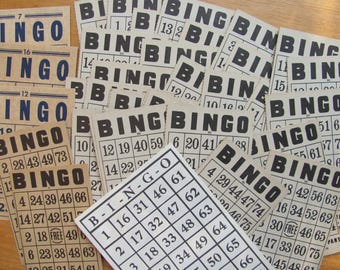 May include: A pile of vintage bingo cards, each displaying the word "BINGO" in large, black lettering. The cards have numbered grids and are scattered on a light surface, reminiscent of a traditional game.