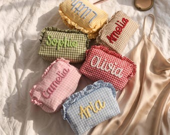 Puede incluir: Seis estuches rectangulares de tela con bordes de volantes y patrones de cuadros vichy en amarillo, verde, rosa, rojo, beige y azul. Cada estuche tiene un nombre bordado en letra cursiva: Lilith, Sophie, Camelia, Amelia, Olivia y Aria.