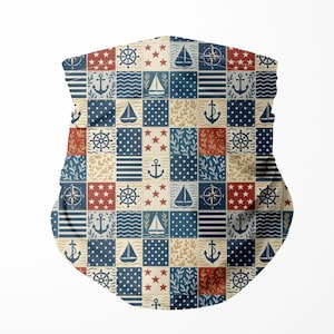 Könnte beinhalten: Eine Gesichtsbedeckung mit einem Patchwork-Design mit nautischen Symbolen. Das Muster zeigt Anker, Segelboote, Steuerräder, Sterne und Kompasse in roten, marineblauen und beigen Quadraten. Die Abdeckung ist für Nase und Mund konzipiert.