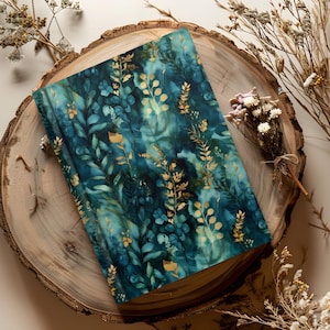 May include: A rectangular notebook featuring a dark teal and blue watercolor background with a pattern of gold-colored botanical leaves and stems. The cover has a smooth finish and displays a dense arrangement of foliage across the entire surface.