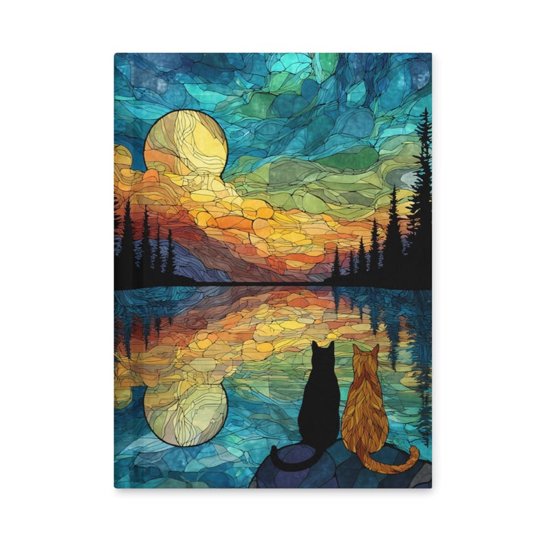 May include: A rectangular wall art print featuring a stained glass style landscape with a yellow moon, orange sunset clouds, and dark silhouettes of pine trees. A black cat and an orange tabby cat sit together on a rock overlooking a lake.