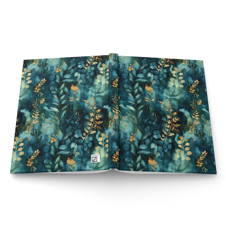 May include: A hardcover book laid open to show the front and back covers. The cover features a dark teal and blue watercolor background with a repeating pattern of golden botanical illustrations, including leaves, ferns, and small flowers.
