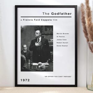 Könnte beinhalten: Ein gerahmtes Schwarz-Weiß-Filmposter für den Film "Der Pate". Das Poster zeigt ein Schwarz-Weiß-Bild von Marlon Brando mit dem Filmtitel, dem Regisseur, der Besetzung und dem Jahr 1972. Das Zitat "AN OFFER YOU CAN'T REFUSE" steht unten.