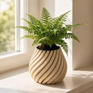 May include: A vibrant green fern plant potted in a cream-colored planter with a distinct spiral, ribbed texture. The planter has a rounded, bulbous shape and sits upright, showcasing the intricate, repeating diagonal grooves along its exterior surface.
