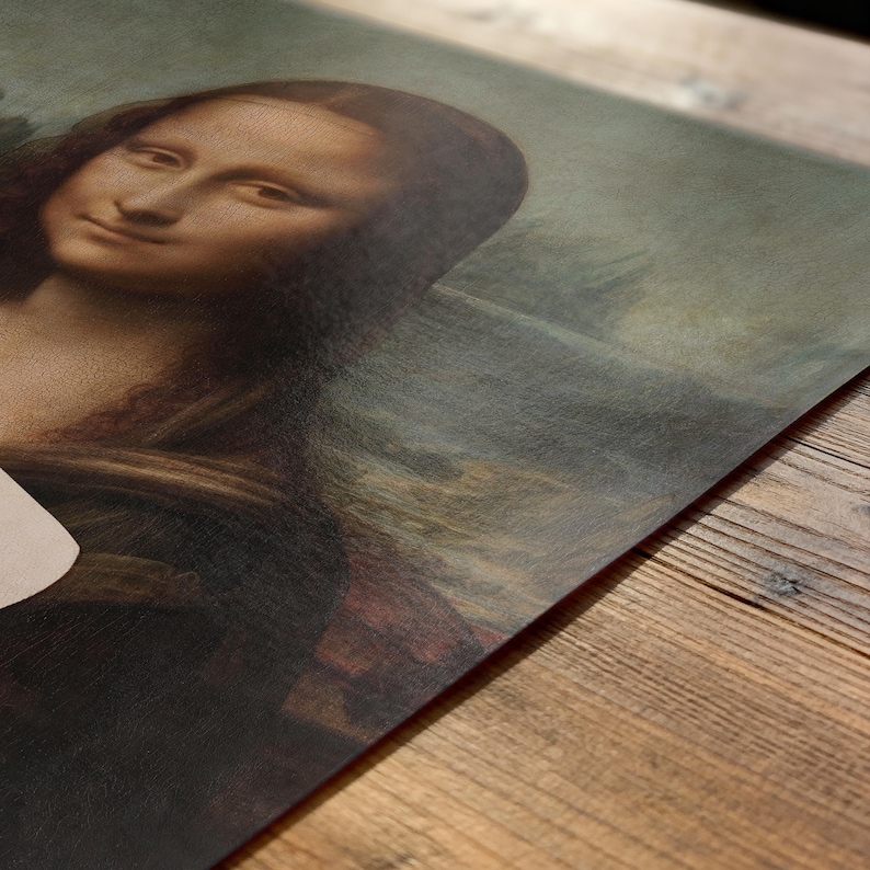 May include: A close-up of a print featuring the Mona Lisa painting. The artwork depicts a woman with a subtle smile, rendered in warm brown and muted green tones. The print is on a textured surface.