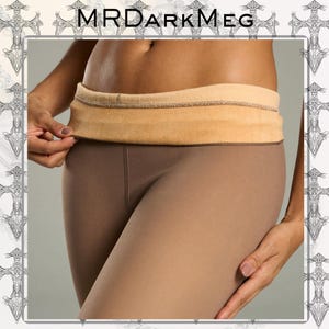 Puede incluir: Leggings de color beige con una cinturilla a juego. La cinturilla es de un tono beige más claro y parece estar hecha de un material suave similar al forro polar. Los leggings son ajustados y lisos.