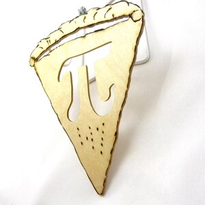 May include: A wooden pie slice ornament with the mathematical symbol pi cut out of the center. The ornament is light brown and has a rustic, hand-crafted look.