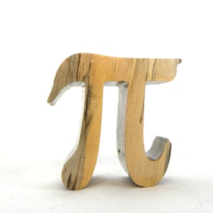 May include: A wooden sculpture of the mathematical symbol pi. The sculpture is made of light brown wood with dark brown streaks.