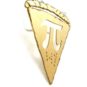 May include: A wooden pie slice ornament with the mathematical symbol pi cut out in the center. The ornament is a light brown color and has a rustic look.