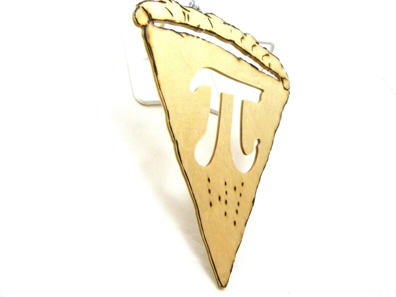 May include: A wooden pie slice ornament with the mathematical symbol pi cut out in the center. The ornament is a light brown color and has a rustic look.