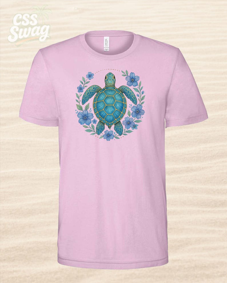 Puede incluir: Camiseta rosa claro con un dise&ntilde;o de tortuga marina turquesa rodeada de flores azules y hojas verdes. La tortuga tiene un patr&oacute;n de caparaz&oacute;n detallado. El texto "CSS Swag" est&aacute; en la esquina superior izquierda.