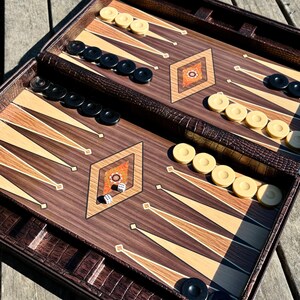 a backgammon game board with pieces and a game in progress, placed on a wooden surface.
