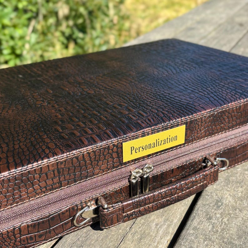 A brown leather briefcase with a textured pattern, placed on a wooden surface.