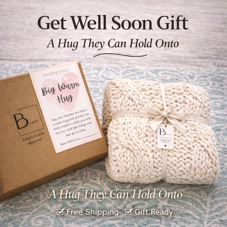 Puede incluir: Una manta de punto color crema atada con una cinta, junto a una caja marr&oacute;n con una etiqueta que dice "Big Warm Hug". Tambi&eacute;n se ve el texto "Get Well Soon Gift" y "A Hug They Can Hold Onto".