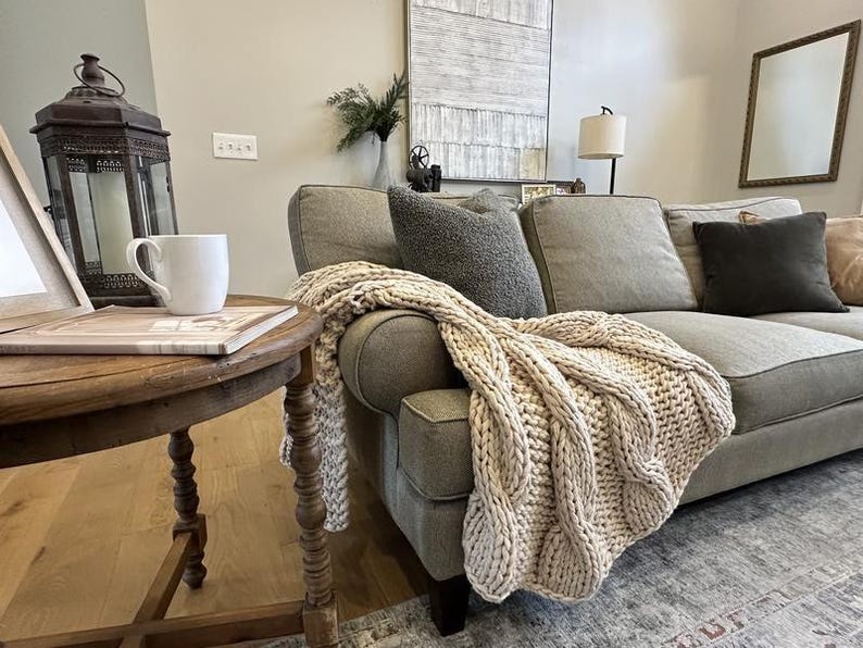 Luxury chunky knit blanket styled in a warm neutral living room, timeless new homeowner gift for sofa, chair, or bedroom