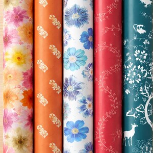Può includere: Una collezione di cinque rotoli di carta da regalo con disegni floreali e a tema natura. I rotoli presentano vari colori, tra cui rosa, arancione, blu, rosso e verde acqua, con motivi di fiori, viti e creature del bosco.