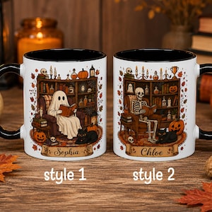 May include: Two white ceramic mugs with black handles and interiors. The left mug features a ghost reading in a chair with the name Sophia. The right mug shows a skeleton reading in a chair with the name Chloe. Both have autumn-themed illustrations.