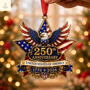 May include: A star-shaped hanging ornament featuring a bald eagle with spread wings, the American flag, and gold text reading 250th ANNIVERSARY UNITED STATES OF AMERICA 1776-2026. The design includes a red ribbon hanger and a small shield at the base.