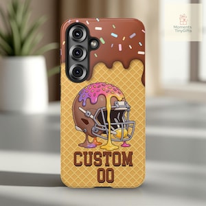 May include: A phone case featuring a football helmet design with a waffle cone background. The top of the case has a chocolate frosting design with sprinkles. The bottom of the case has the text "CUSTOM 00".