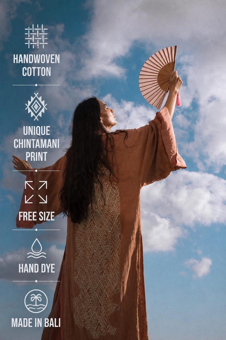 a woman wearing a brown robe and holding a fan, with a blue sky and clouds in the background.