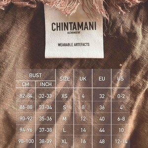 a label with measurements and sizes for a garment, along with a list of bust, size, and country measurements.