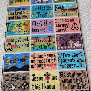 May include: A beaded wall hanging with colorful squares featuring Christian Bible verses. The verses include "The Lord is my shepherd", "In God We Trust", "Fear not for I am with you", "Jesus, I Trust in You", "Love keeps no record of wrongs", "Be still and know that I am God", and more.