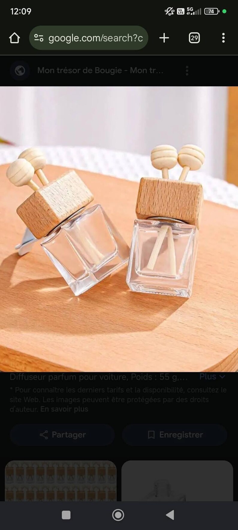 Op de afbeelding: Twee heldere glazen auto-geurverspreiders met houten tops en decoratieve houten accenten. Elk heeft een rechthoekige glazen fles met een houten dop en twee houten stokjes. De achtergrond is een lichtbruin oppervlak.