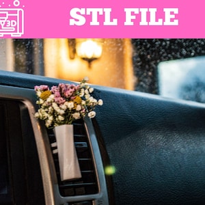 Könnte beinhalten: Eine kleine weiße Vase mit einem Blumenstrauß befindet sich in der Lüftungsöffnung eines Autos. Das Bild zeigt das Armaturenbrett und die Windschutzscheibe des Autos. Der Text "STL FILE" wird oben im Bild angezeigt.