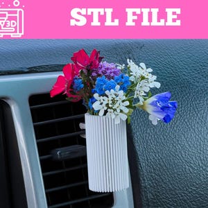 May include: A white, ribbed, 3D-printed car vent vase holding a colourful bouquet of flowers. The flowers include red, blue, purple, and white blooms. The text "STL FILE" is displayed in white on a pink background.