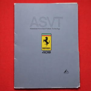 Peut inclure: Une brochure rectangulaire grise intitulée ASVT Aluminum Structured Vehicle Technology. La couverture présente un logo Ferrari jaune avec un cheval cabré noir, le texte Ferrari 408 et un petit logo Alcan dans le coin inférieur droit.