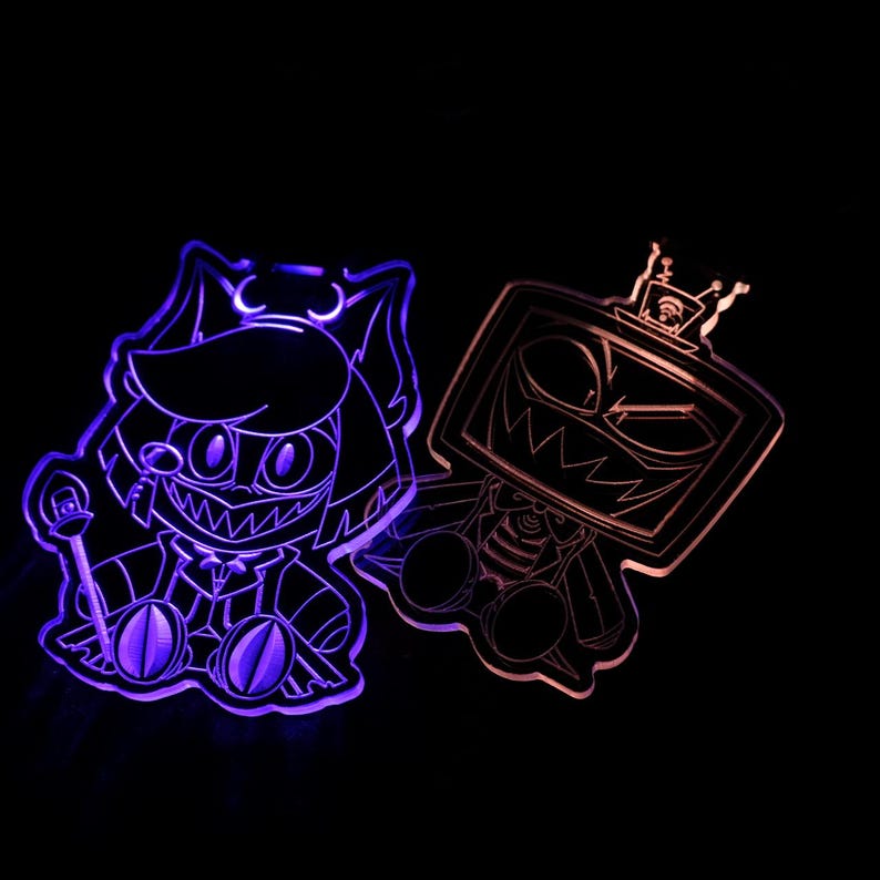 May include: Two acrylic character cutouts with LED lighting. One is purple and features a cat-like character with a staff. The other is orange and has a TV-headed character with a crown. Both have a cartoonish, menacing design.