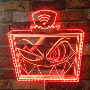 May include: A red neon sign featuring a stylized face with sharp teeth and an eye with a lightning bolt. The sign has a wifi symbol on top and is mounted on a brick wall. The sign is lit with red LED lights.