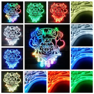 Puede incluir: Un letrero LED decorativo con el texto "ON AIR" y un dise&ntilde;o de personaje estilizado. El letrero est&aacute; iluminado con varios colores, incluyendo rojo, verde, azul y blanco. El dise&ntilde;o est&aacute; montado en una pared de ladrillo.