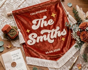 May include: A rust-colored velvet wall banner featuring the embroidered text "CALIFORNIA", "The Smiths", and "25.06.2026" in white script. The banner includes three yellow embroidered stars, a wooden dowel, white tassels, and white fringe trim.