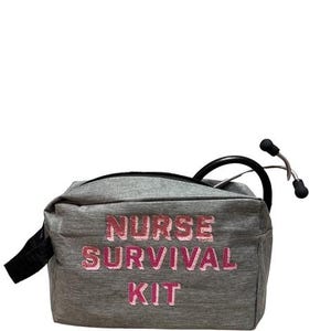 May include: A gray fabric bag with the words "NURSE SURVIVAL KIT" in pink lettering. A black stethoscope is partially visible, emerging from the bag. The bag has a black zipper and a black handle.